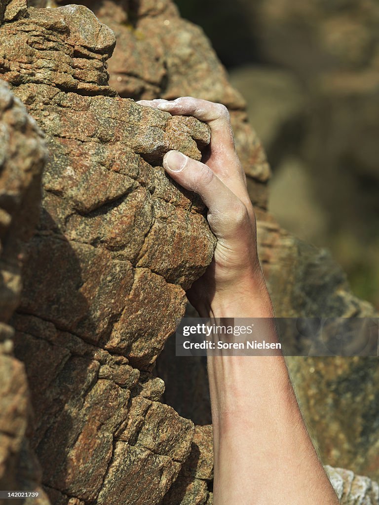 Rock climbers hand on steep rock face