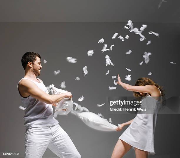 couple having pillow fight - pillow fight fotografías e imágenes de stock