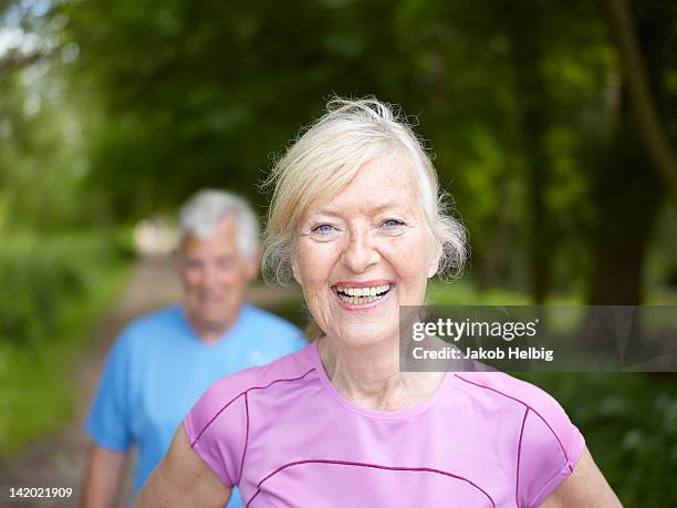 smiling older woman standing outside - active lifestyle seniors stock pictures, royalty-free photos & images