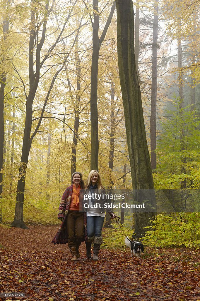 Women walking dog in forest