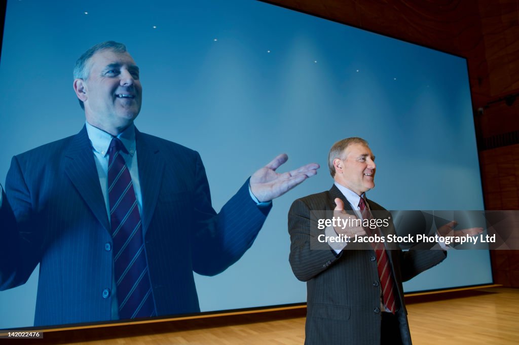 Caucasian businessman making speech in front of monitor