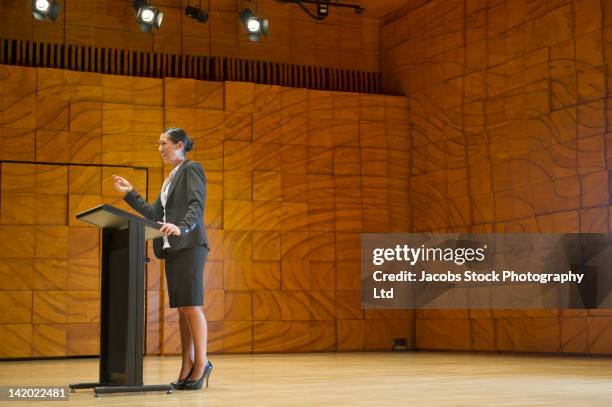 hispanic businesswoman making speech at podium - discours-liminaire photos et images de collection