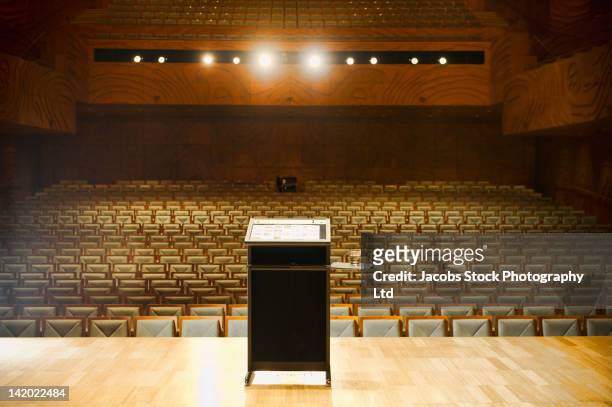 podium on stage in empty auditorium - lectern stock-fotos und bilder