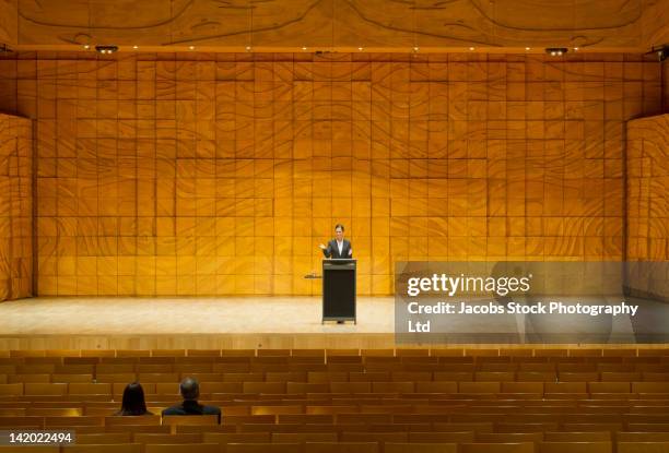hispanic businesswoman practicing speech in empty auditorium - discorso programmatico foto e immagini stock
