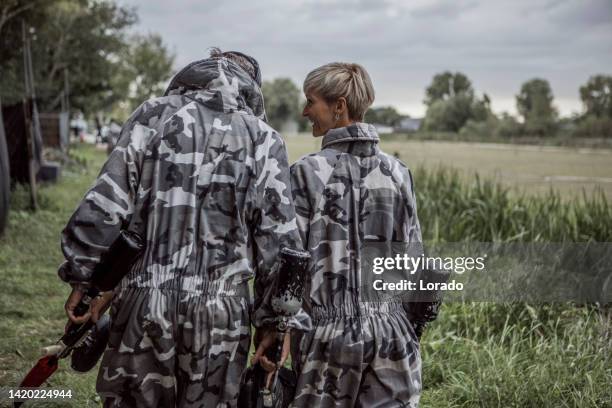 portrait of a middle aged paintball husband and wife team - paintball stock pictures, royalty-free photos & images
