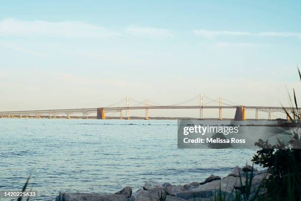 view of the chesapeake bay bridge at sunset. - côte est du maryland photos et images de collection