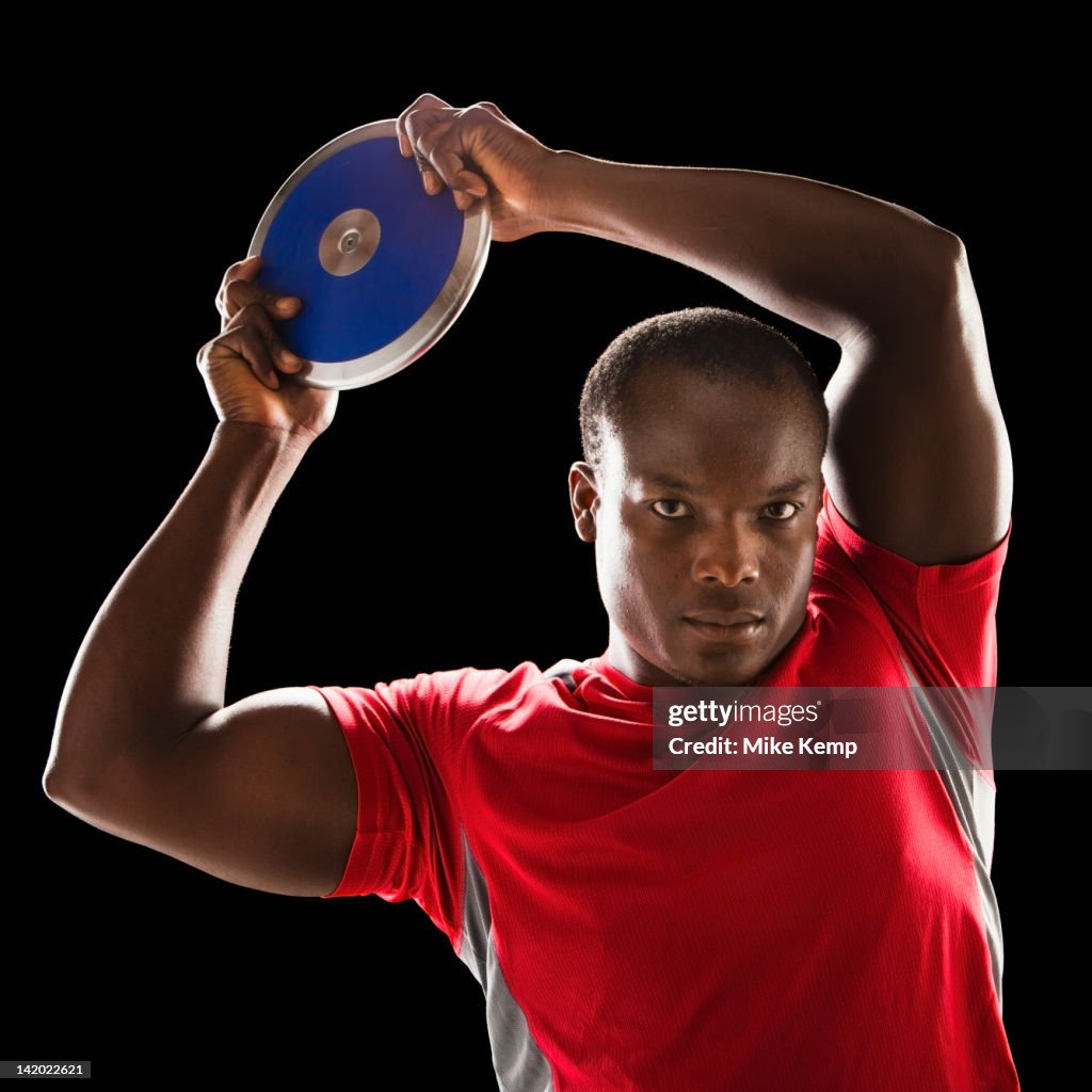 African American man holding track and field discus