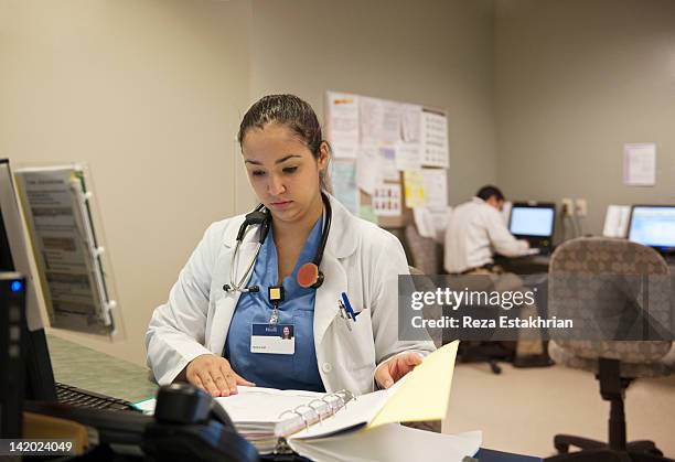 female doctor checks medical case notes - concentration stock pictures, royalty-free photos & images