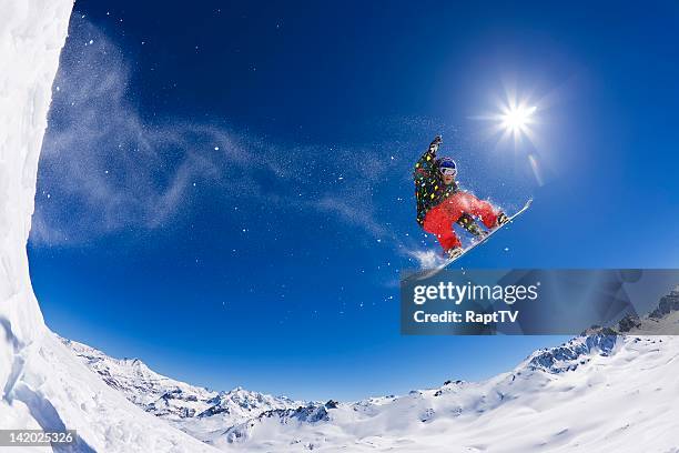 snowboarder jumping across snowy mountain - freestyle snowboarding stock pictures, royalty-free photos & images