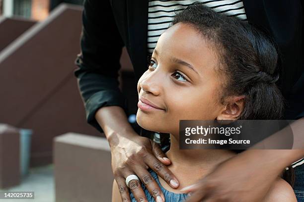 girl standing with mother, looking away - contemplation family stockfoto's en -beelden