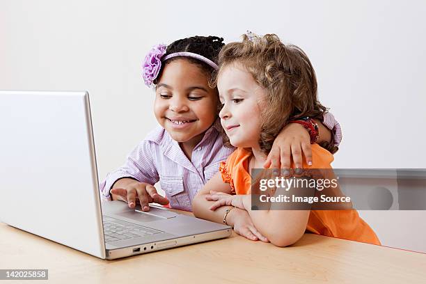 girls looking at laptop together - embracing digital stock pictures, royalty-free photos & images