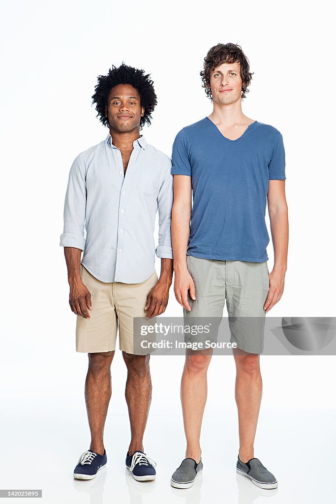 Gay couple standing against white background