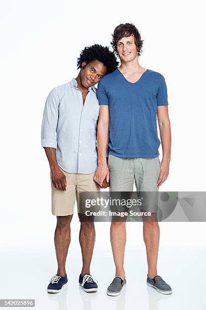 gay couple standing against white background - black and white holding hands stock-fotos und bilder