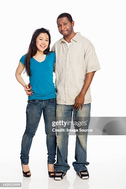 mixed race couple standing against white background - mixed race man standing studio stockfoto's en -beelden