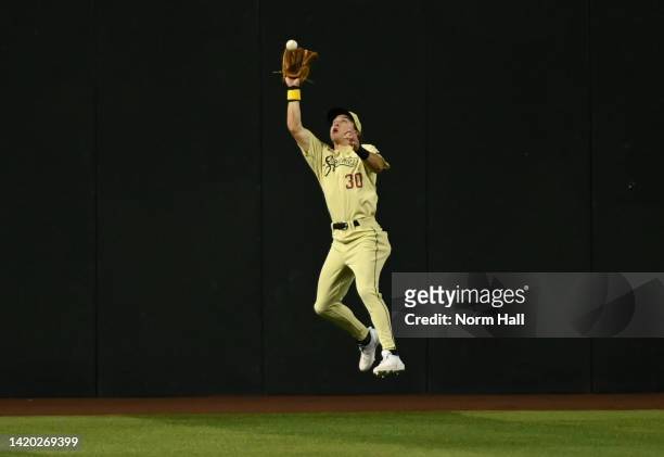 Jake McCarthy of the Arizona Diamondbacks makes a leaping catch on a line drive hit by Kolten Wong of the Milwaukee Brewers during the first inning...