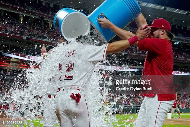 Spencer Steer of the Cincinnati Reds is dunked with water after scoring the winning run in the ninth inning to beat the Colorado Rockies 3-2 at Great...