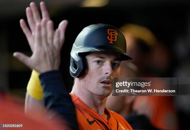 Mike Yastrzemski of the San Francisco Giants is congratulated by teammates after he scored against the Philadelphia Phillies in the bottom of the...