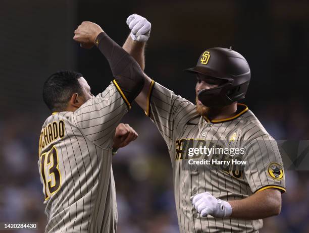 Brandon Drury of the San Diego Padres celebrates his two run homerun with Manny Machado, to take a 4-0 lead over the Los Angeles Dodgers, during the...