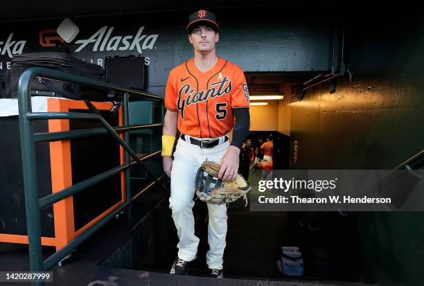 Mike Yastrzemski of the San Francisco Giants walking into the dugout wearing a yellow wrist band and yellow ribbon on his jersey prior to the start...