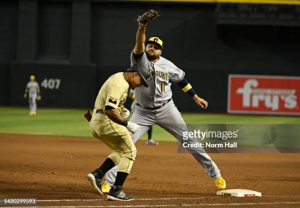 Rowdy Tellez of the Milwaukee Brewers stretches off first base to catch a throw from Luis Urias as Wilmer Difo of the Arizona Diamondbacks is forced...