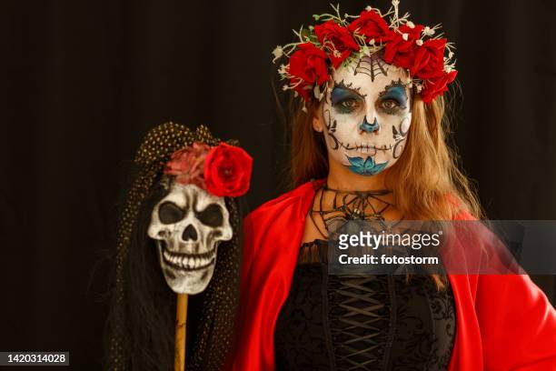 schöne mittelerwachsene frau mit einem halloween-kostüm und einem zuckerschädel-make-up - bühnenkostüm stock-fotos und bilder