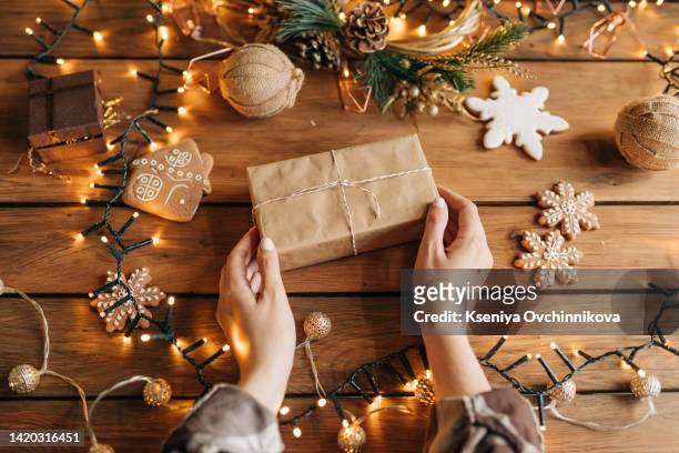 merry christmas and happy holidays a mother, father and their daughter prepare xmas gifts. baubles, presents, candy with christmas ornaments. top view. christmas family traditions. - happy new month stockfoto's en -beelden