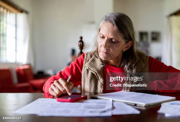 senior woman working at home doing some paperwork - ethnicity stock pictures, royalty-free photos & images