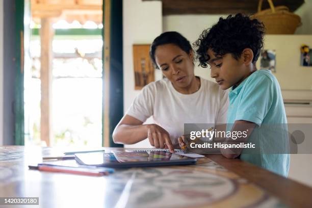 boy homeschooling with the assistance of his mother - pobreza questão social imagens e fotografias de stock