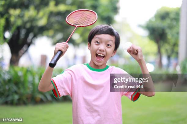 junge, der badminton im öffentlichen park spielt - playing badminton stock-fotos und bilder