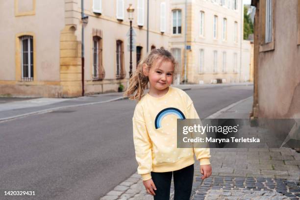 portrait of a young child girl on the street of the old city. spending time in the fresh air. - sweatshirt fotografías e imágenes de stock