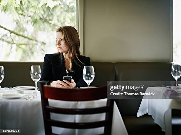 businesswoman in restaurant looking out window - dining experience stock pictures, royalty-free photos & images