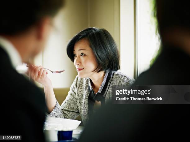 businesswoman at table in restaurant eating - elegant spoon stock pictures, royalty-free photos & images