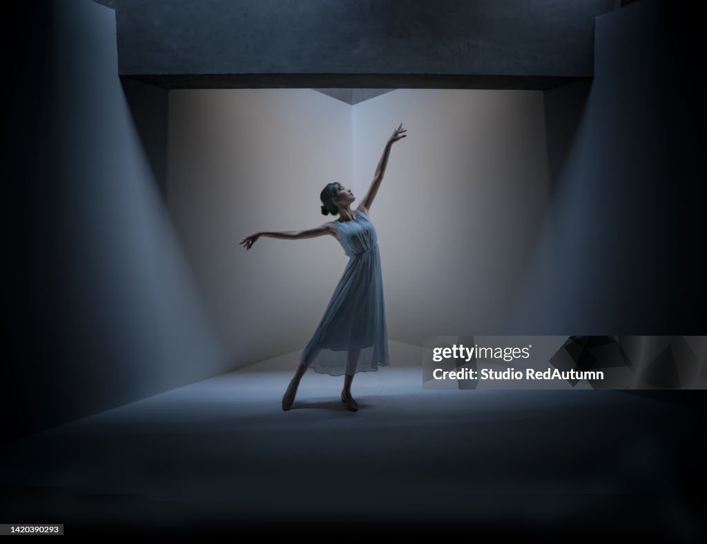 Young woman in blue dress dancing on the stage