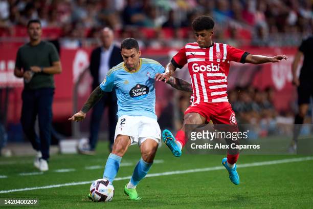 Hugo Mallo of RC Celta is challenged by Oscar Urena of Girona FC during the LaLiga Santander match between Girona FC and RC Celta at Montilivi...