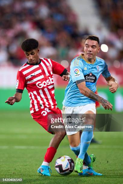 Iago Aspas of RC Celta is challenged by Oscar Urena of Girona FC during the LaLiga Santander match between Girona FC and RC Celta at Montilivi...