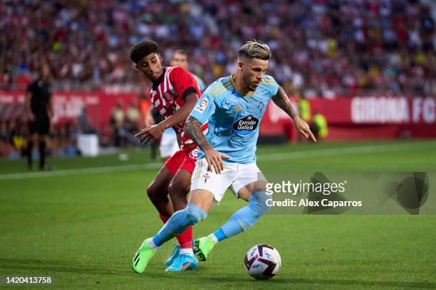 Carles Perez of RC Celta is challenged by Oscar Urena of Girona FC during the LaLiga Santander match between Girona FC and RC Celta at Montilivi...