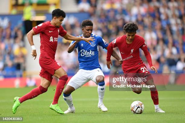 Luis Diaz and Fabio Carvalho of Liverpool are challenged by Demarai Gray of Everton during the Premier League match between Everton FC and Liverpool...