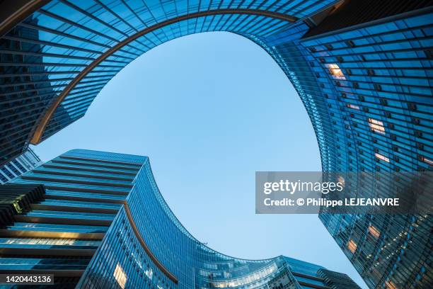 modern curved glass skyscraper facades reflecting clear blue sky at night - china abstract photos et images de collection