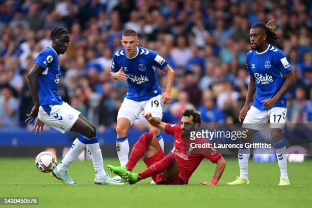 Mohamed Salah of Liverpool is challenged by Amadou Onana, Alex Iwobi and Vitaliy Mykolenko of Everton during the Premier League match between Everton...