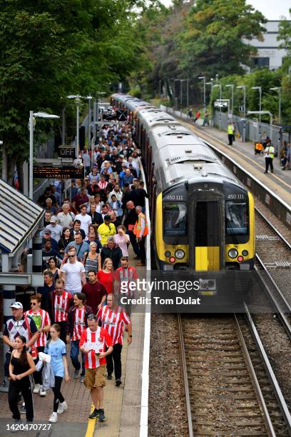 Fans get off a train as they arrive prior to kick off of the Premier League match between Brentford FC and Leeds United at Brentford Community...