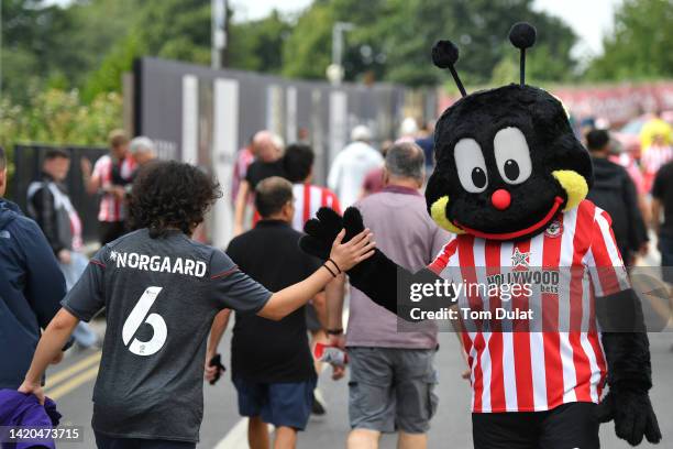 The Brentford mascot interacts with fans on the outside of the stadium prior to kick off of the Premier League match between Brentford FC and Leeds...