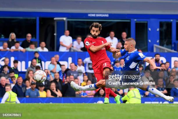 Mohamed Salah of Liverpool is challenged by Vitaliy Mykolenko of Everton as their shot hits the post during the Premier League match between Everton...