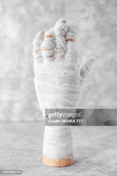 mummy hand wrapped in bandages on gray background. spooky halloween night. halloween celebration concept. - artists model stock pictures, royalty-free photos & images
