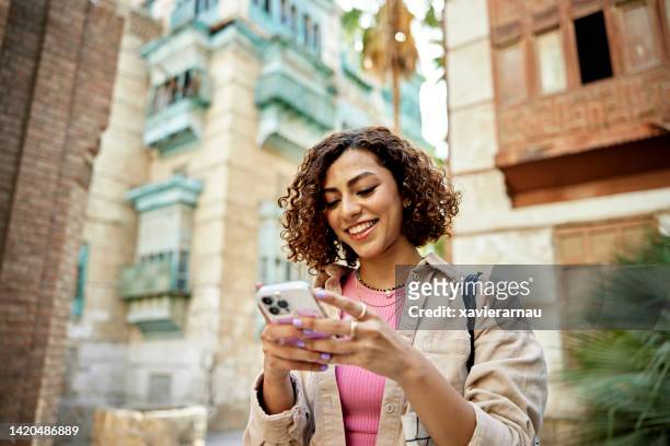 candid portrait of young middle eastern digital native - smartphone stock pictures, royalty-free photos & images