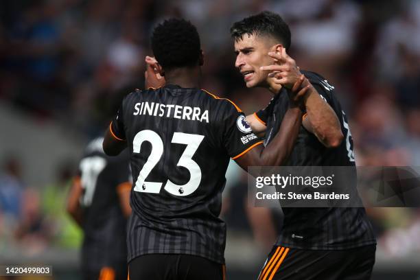 Luis Sinisterra of Leeds United celebrates scoring their side's first goal with teammate Marc Roca during the Premier League match between Brentford...