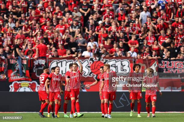 Matthias Ginter of SC Freiburg celebrates with teammates after scoring their team's first goal during the Bundesliga match between Bayer 04...