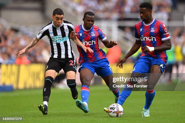 Miguel Almiron of Newcastle United is challenged by Tyrick Mitchell and Marc Guehi of Crystal Palace during the Premier League match between...