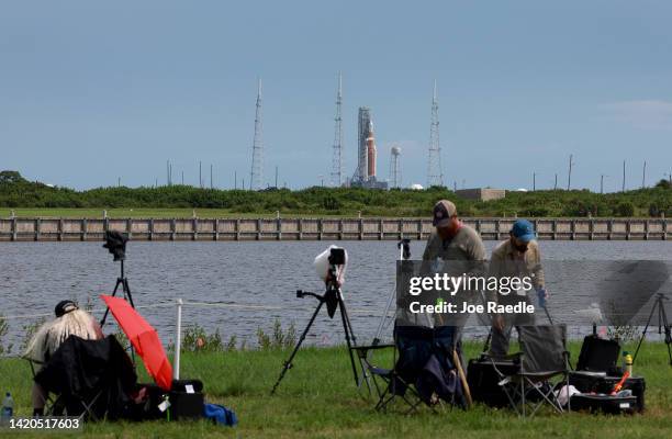 Photographers pack up their gear as NASA's Artemis I rocket sits on launch pad 39-B after the launch was scrubbed at Kennedy Space Center on...