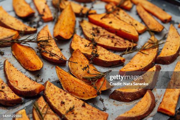tray of oven baked sweet potato chips in closeup. - zoete aardappel stockfoto's en -beelden
