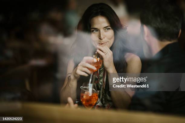 woman enjoying drink with boyfriend in restaurant - couples romance stock-fotos und bilder